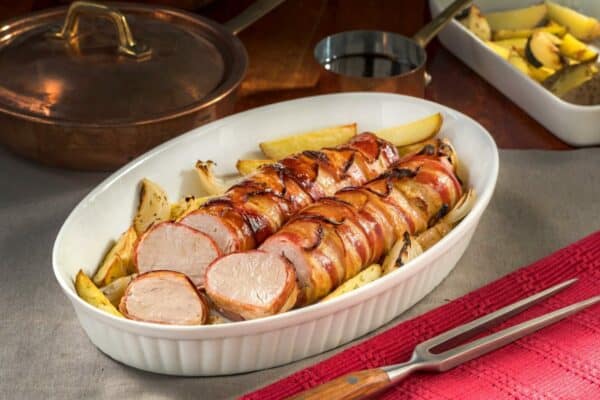 Filete de cerdo envuelto en tocino con papas al horno